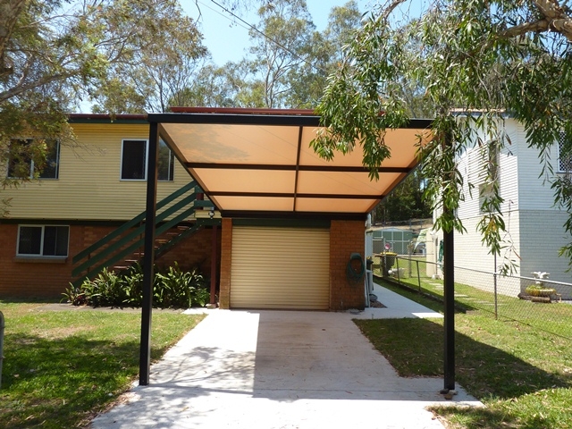 Freestanding carport with flat roof.