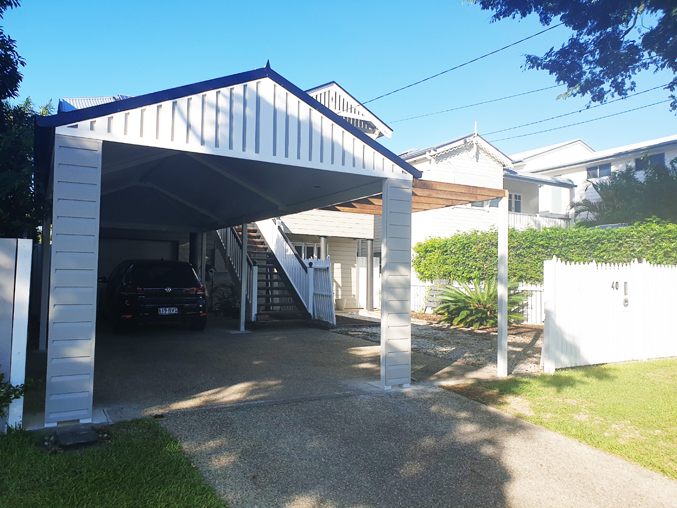 Gable carport with fully welded and Dulux powder coated. All-Gal trusses and beams. Weather board cladding and a fibre cement sheet with decorative cover strips to create an appealing facade. This structure is complete with a hardwood planter trellis.